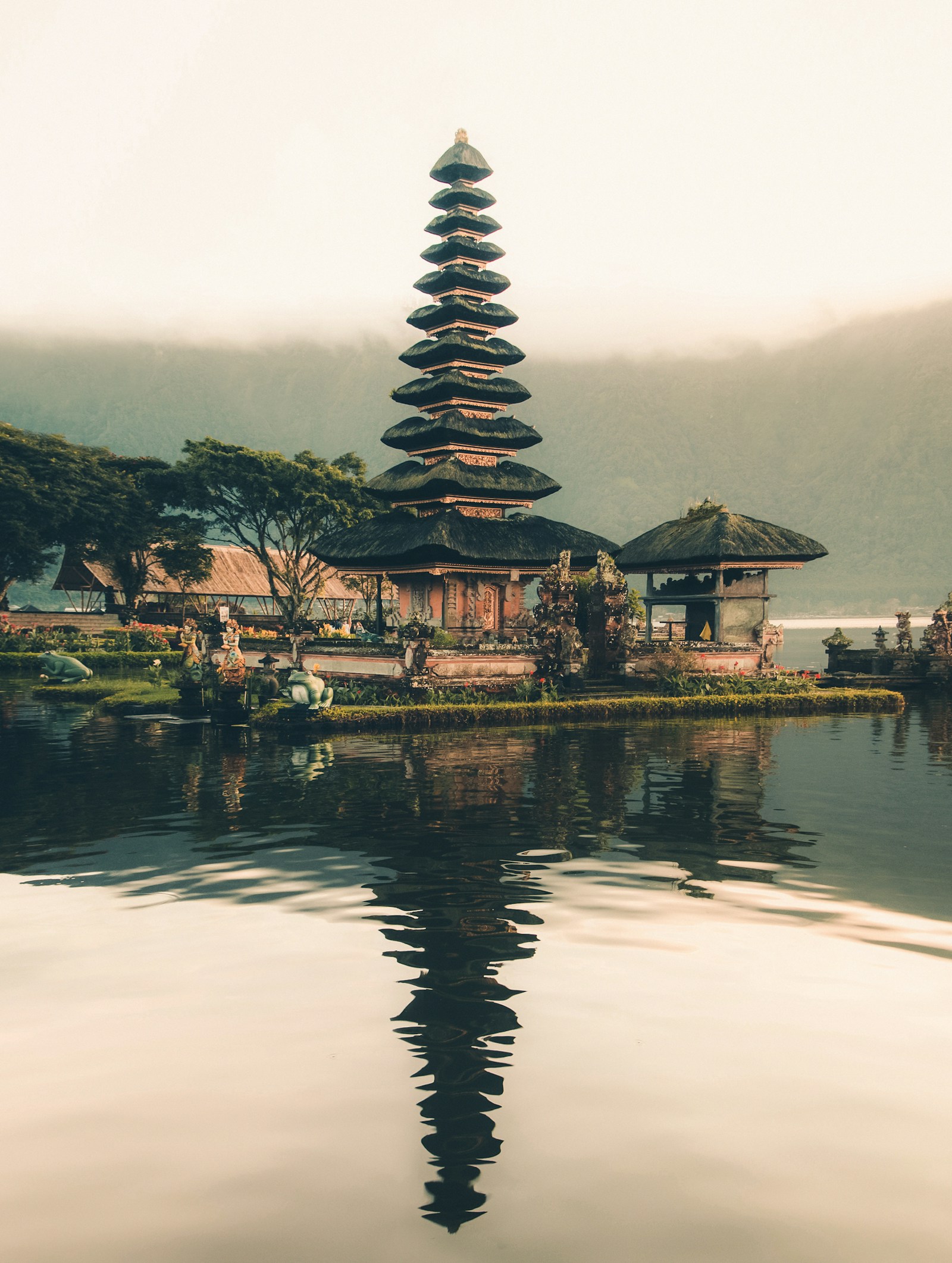 Templo balinés junto al lago, rodeado de jardines y montañas